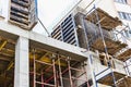 Construction of a new monolithic reinforced concrete house. Scaffolding on the facade of a building under construction. Working at Royalty Free Stock Photo