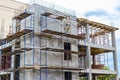 Construction of a new monolithic reinforced concrete house. Scaffolding on the facade of a building under construction. Working at Royalty Free Stock Photo