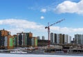 Construction of a new multi-storey building in the city, red construction crane on a blue cloudy sky background, construction site Royalty Free Stock Photo