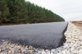 Construction of a new road. Fresh asphalt laying. The beginning of the road