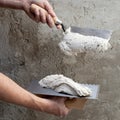 Construction notched trowel and worker hands