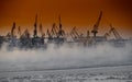 The construction of nuclear icebreakers at magic sunset, cranes of of the Baltic shipyard in a frosty winter day, steam Royalty Free Stock Photo