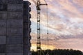 Construction of a panel frame house at sunset using a tower crane. Back light. Work at night on the construction of a residential Royalty Free Stock Photo