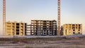 Construction of a panel frame house at sunset using a tower crane. Back light. Work at night on the construction of a residential Royalty Free Stock Photo