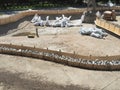 Construction of a park pool with stones laid between fences and bags lying in a depression on a sunny day