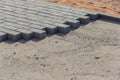 Bricklayer places concrete paving stone blocks for building up a Sidewalk pavement Royalty Free Stock Photo