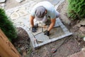 Construction of pavement near the house. Bricklayer places concrete paving stone blocks for building up a Sidewalk Royalty Free Stock Photo