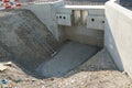 Construction pit or shaft on civil engineering construction site with two concrete walls and with a metal ladder for better acces