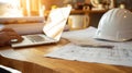 The construction plans on a desk with a laptop and hardhat nearby. AI generated image Royalty Free Stock Photo