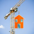 The construction of a prefabricated building - concept with tower crane and prefab leaning house Royalty Free Stock Photo