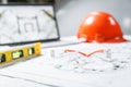 Construction protective glasses,orange hard hat, laptop  with drawings, level meter lying in a  blueprints on a table Royalty Free Stock Photo