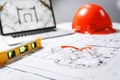 Construction protective glasses,orange hard hat, laptop  with drawings, level meter lying in a  blueprints on a table Royalty Free Stock Photo