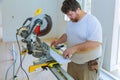 Building contractor worker using measuring and marking a before cutting wooden trim board