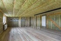 Construction and renovation of big spacious empty unfinished attic room with oak floor, walls and ceiling insulated with rock woo