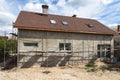 Construction or repair of the rural house with insulation, eaves, windows, chimney, roofing, fixing facade, plastering walls.
