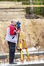 Construction of a residential area. Geodetic stakeout. Surveyor at a large construction site. A man with a tachometer during work Royalty Free Stock Photo