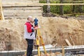 Construction of a residential area. Geodetic stakeout. Surveyor at a large construction site. A man with a tachometer during work Royalty Free Stock Photo