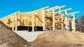 Construction of a residential building from glued profiled wooden beams or glulam in spring. Concrete foundation for a residential Royalty Free Stock Photo