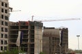 Construction of residential multi-apartment high-rise buildings. Crane booms over buildings under construction