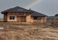 Construction residential new house in progress at building site. Rainbow in the sky Royalty Free Stock Photo