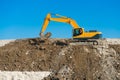 Construction of the road. Excavator modified photo levels the mound of sand.