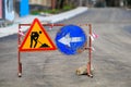 Construction road signage with arrow and worker icon on asphalt street Royalty Free Stock Photo