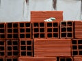 Construction rubber glove with a finger pointing over a pile of mud bricks on a construction site