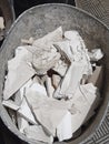 Aerial view of broken pieces of plaster inside a bucket or bricklayer`s drawer. Construction rubble background. Architecture and