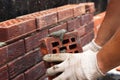 Construction of a rural house. Applying cement to brick. Gloved hands and trowel. selective focus