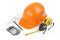 Construction safety helmet posing on paper blueprints, tape measure, pencil and calculator, isolated on white background Royalty Free Stock Photo