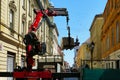 Truck and hydraulic arm, lifting mechanism transferring clay brick stack on palette to construction site. street scene