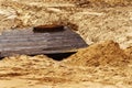 Construction of a sewer collector. A fragment of a concrete structure with a metal hatch on a sandy ground. Copy space