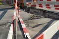 Construction shaft cut in asphalt or bituminous carpet bordered by barrier planks in red and white