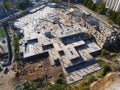 Construction site aerial view. Mall building base with solid concrete pillars. Heavy machinery and high tower crane working. Royalty Free Stock Photo