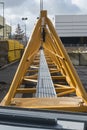 Construction site with arm of a yellow towercrane for lifting building materials lying on the floor before assembly