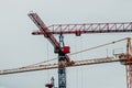 Construction site. Big industrial tower cranes with unfinished high raised buildings and blue sky in background. Scaffold. Modern