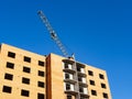 Construction site of brick multistory building with crane under blue sky Royalty Free Stock Photo