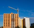 Construction site of brick multistory building with crane under blue sky, new condominium on the background. Affordable housing Royalty Free Stock Photo