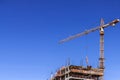 Construction site building with crane on blue sky background copy space. Royalty Free Stock Photo