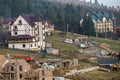 Construction site with building crane and new modern comfortable hotel house with shingled roof in ecological rural area on spruce Royalty Free Stock Photo