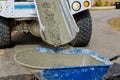 During a construction site, a concrete mixer truck is pouring wet cement into a wheelbarrow Royalty Free Stock Photo