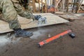 Construction Site. Construction worker with electrical circular saw saws the cement particle board oudoor near house