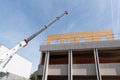 Construction site crane is lifting a precast wooden wall panel Royalty Free Stock Photo