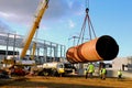 Steel pipe lift by a crane on a construction site