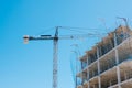 Construction site with crane over blue sky background. Construction of modern apartment house, new skyscraper building Royalty Free Stock Photo