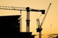 Construction site with crane at sunset.silhouette of construction tower crane group with sunset sky background Royalty Free Stock Photo