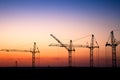 Construction site with cranes against a sunset sky Royalty Free Stock Photo