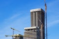 A construction site with cranes and a blue sky backdrop Royalty Free Stock Photo