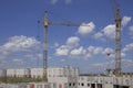 Construction site with cranes and building with cloudy sky background Royalty Free Stock Photo