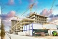 Construction site with cranes for a large office building under blue skies